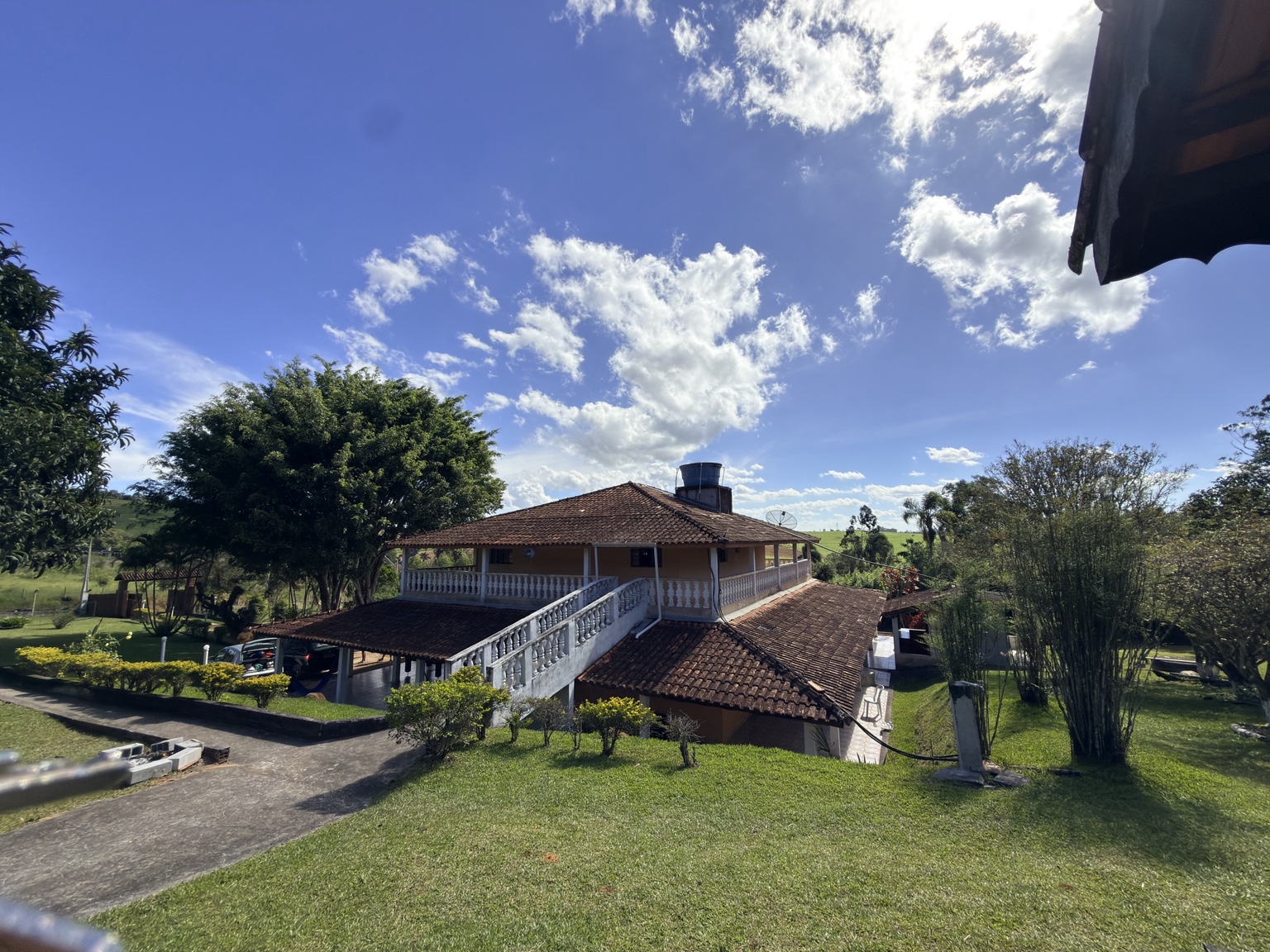 Vista ampla da casa e do gramado do sítio